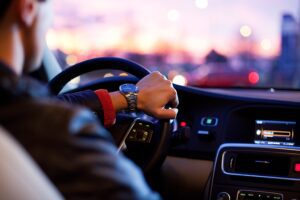 SR-22 - Closeup View of a Man Driving His Vehicle with Outside of Car Out of Focus at Dusk