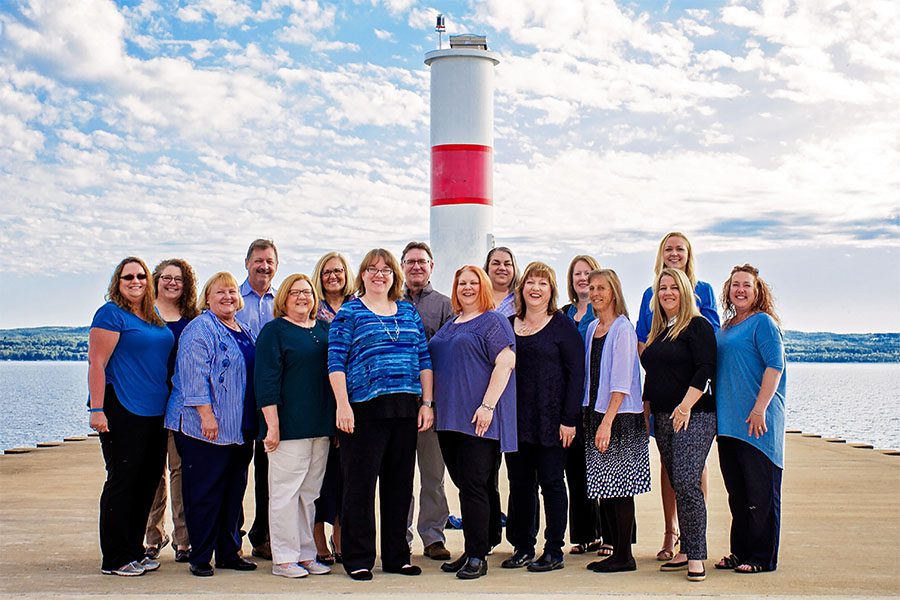 About Our Agency - Portrait of the Harbor Brenn Insurance Agencies Staff Standing in Front of the Lighthouse on the Harbor in Petoskey Michigan