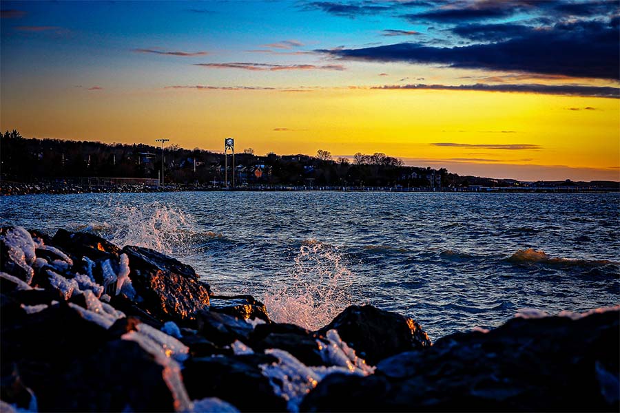 About Our Agency - Scenic View of the Waves Splashing Against the Rocks on the Coastline of Petoskey Michigan at Sundown