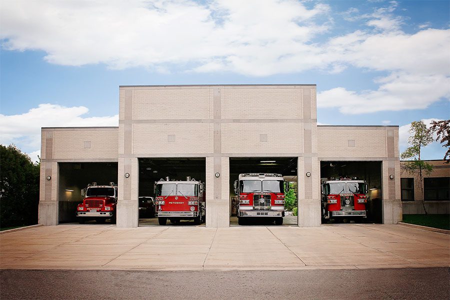 About Our Agency - View of the Fire Station with Parked Fire and Emergency Trucks Against a Cloudy Sky in Petoskey