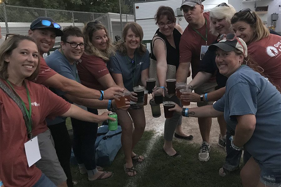 Our Culture - Harbor Brenn Insurance Staff Holding Beers for a Toast at a Festival